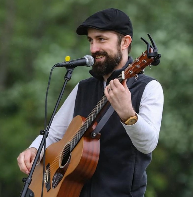 A person playing guitar and singing into a microphone

AI-generated content may be incorrect.